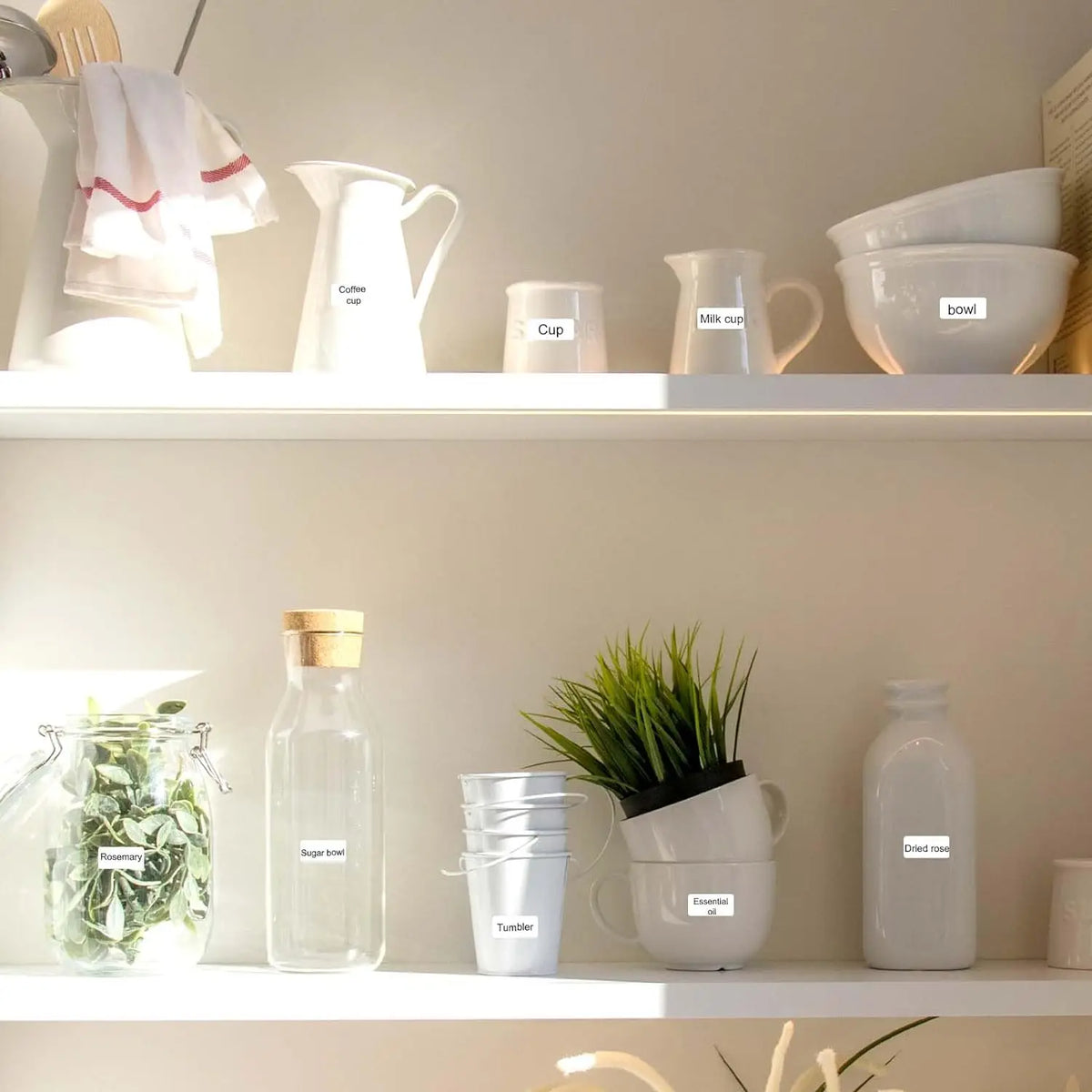 Étagère de cuisine où pichets, tasses, bocaux et bouteilles portent chacun une étiquette blanche
