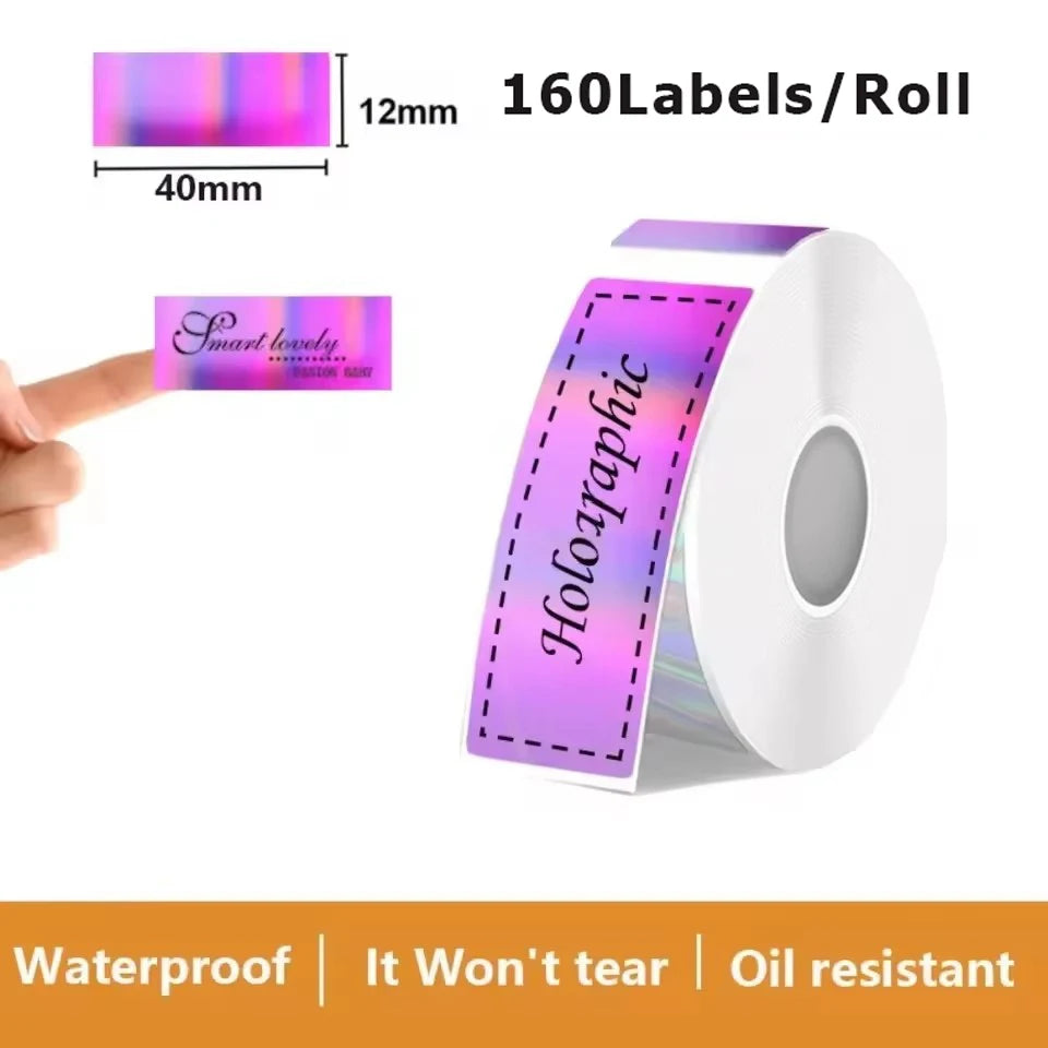 Rouleau d'étiquettes irisées violet et rose portant la mention Holographic, coté 40 x 12 mm, et étiquette Smart lovely tenue entre deux doigts