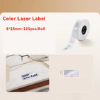 Rouleau d'étiquettes laser irisées 8 x 25 mm et étiquette de prix irisée posée près d'une paire de lunettes
