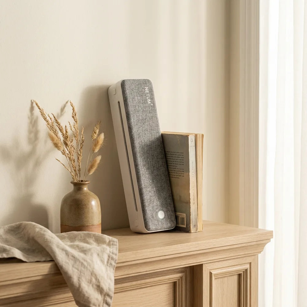 Imprimante thermique A4 design debout sur une étagère à côté d'un livre