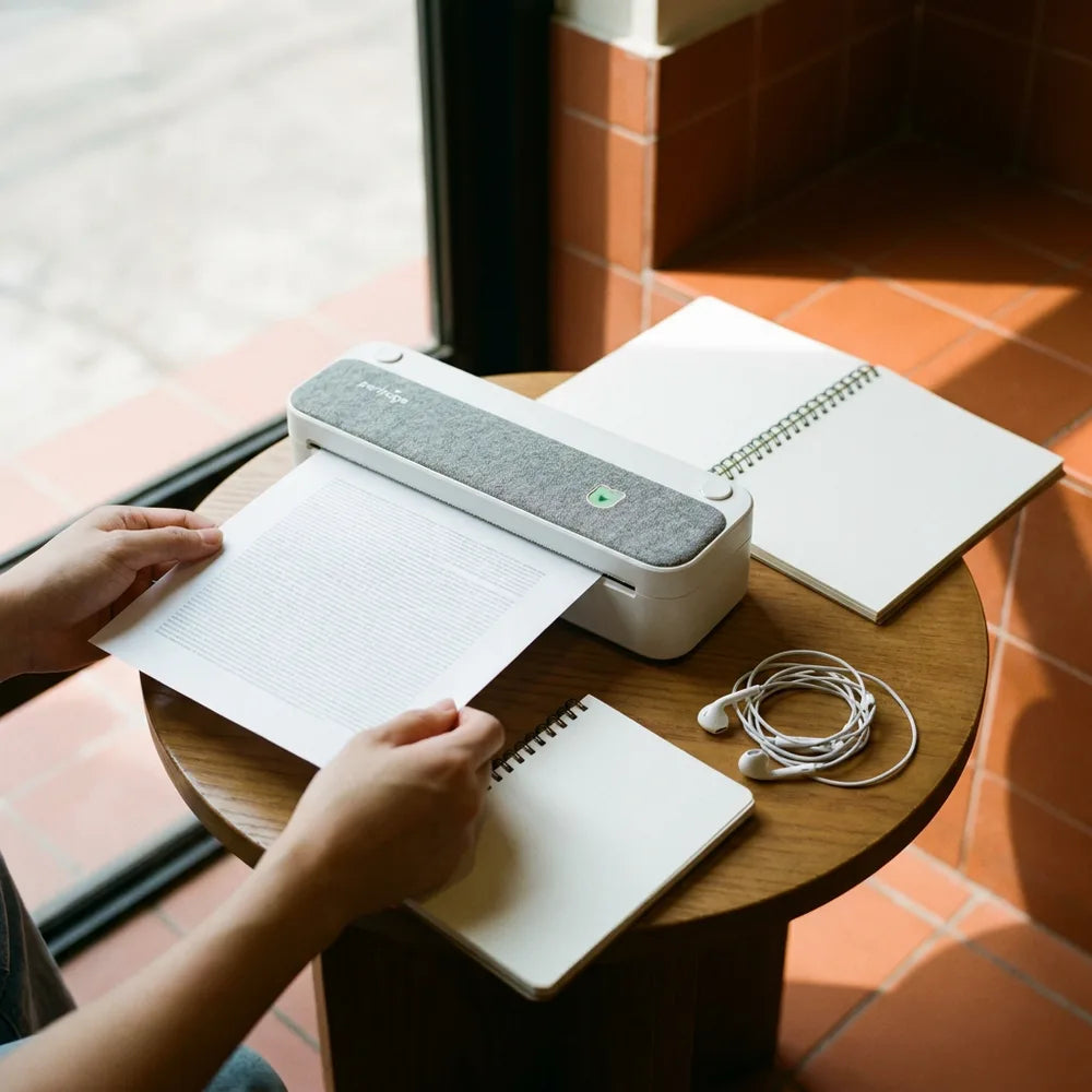 Étudiant récupérant une page imprimée au café avec l'imprimante thermique A4