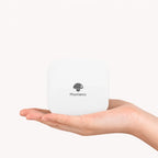 Imprimante thermique portable format poche blanche posée dans une paume ouverte, fond crème